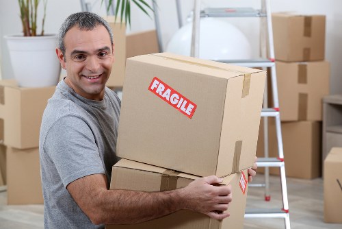 Moving boxes and furniture being loaded for a Kingston man and van service